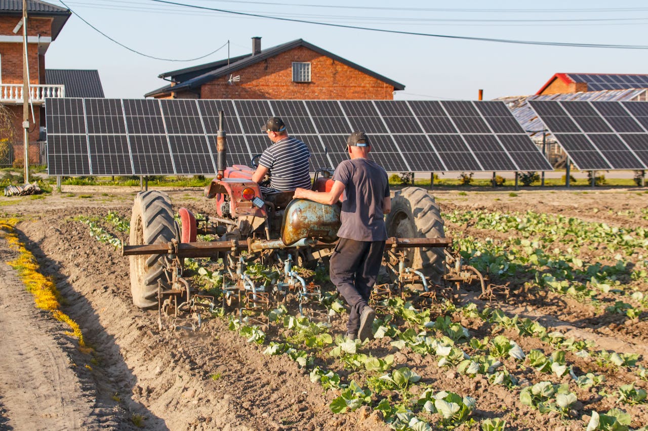 Farmers using tractor near solar panels symbolize modern sustainable agriculture.
